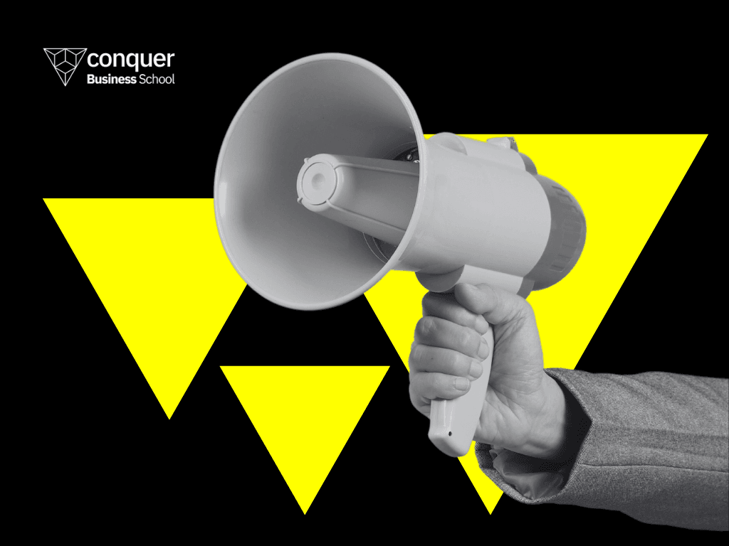 Mão segurando um megafone mostrando que a comunicação com a equipe é uma habilidade essencial.